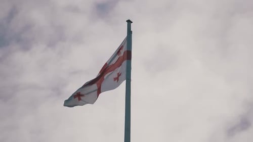 Georgian Flag Waving Against Cloudy Sky