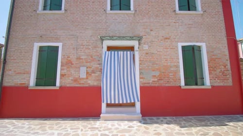 Casa de revestimiento de ladrillo con cortina que cubre la puerta de entrada