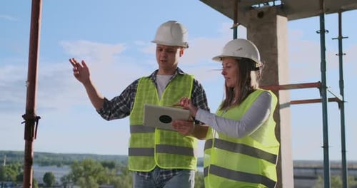 Building Technology and People Concept Smiling Builders in Hardhats with Tablet Pc Computer Outdoors