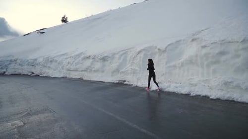 Confident Woman in Jogging Pants Running in Snow Corridor in the Mountains in Bulgaria