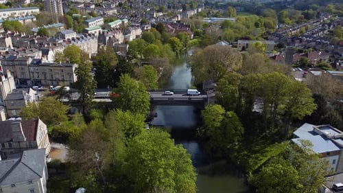 Vista aerial of an old victorian bridge surrounded by a luscious green and inner city landscape, Ba