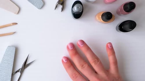 Woman's Hand with Pink Manicure and Nail Supplies