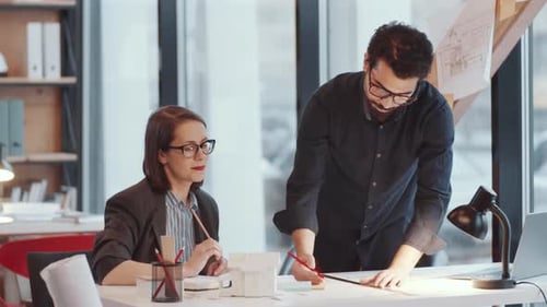 Architects Collaborating on a Blueprint in Modern Office