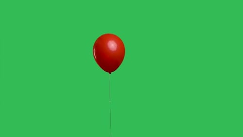 Red Oval Shaped Balloon Hanging in the Air Against the Background of a Green Screen Chroma Key
