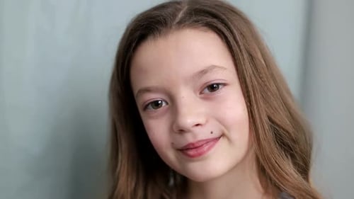 Beautiful little girl laughs at the camera close-up