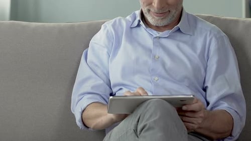 Senior Man Using Tablet Computer on Couch