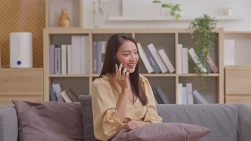 Woman Chatting Happily on Cell Phone at Home