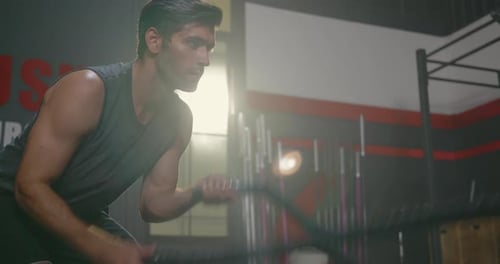Man Using Battle Ropes for Gym Workout