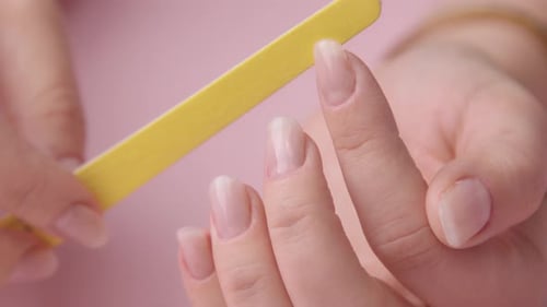 Woman Files Nails with Yellow Nail File