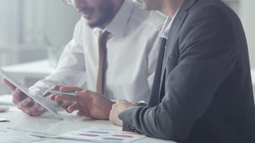 Close Up of Two Businessmen Using Tablet and Having Discussion