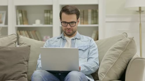Young Man Leaving Laptop and Going Away at Home