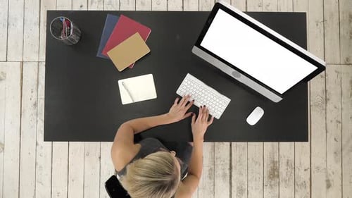 Junge Frau arbeitet an ihrem Schreibtisch mit Computer. Weißes Display