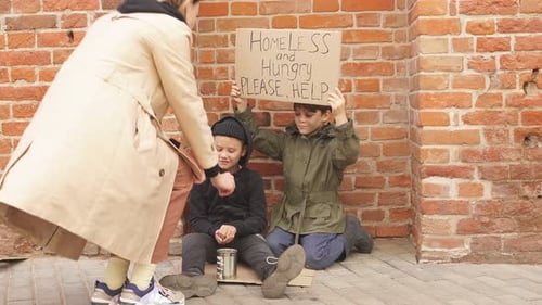 Stranger Woman in Street Helping Homeless Children Talking Stroking Head of Kid Sitting on Ground