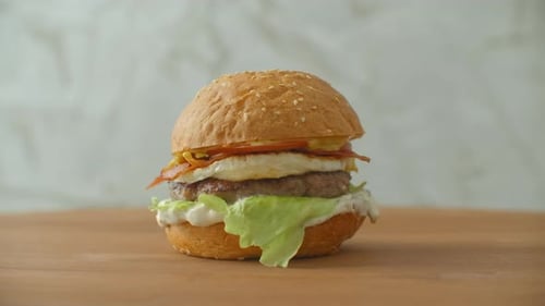 Delicious Hamburger With Egg on Wooden Board