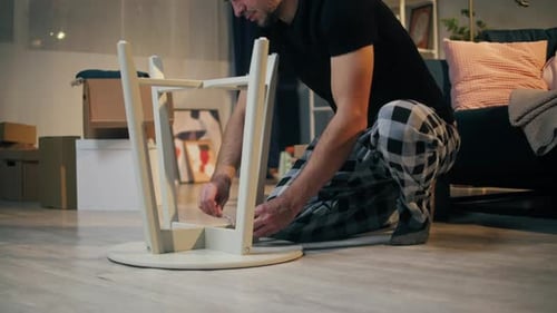 Man Assembling Light Wood Table Indoors