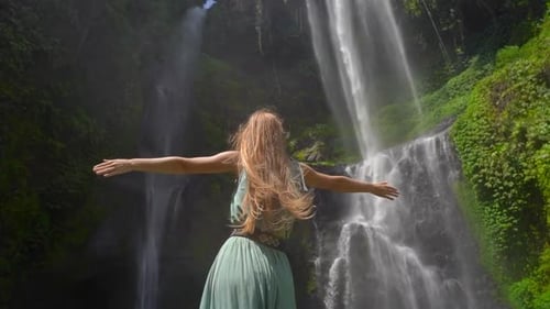 Young Woman Tourist Visits the Biggest Waterfall on the Bali Island - the Sekumpul Waterfall