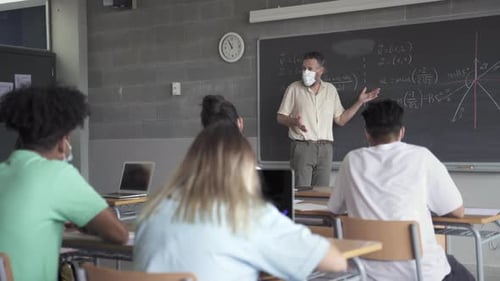 Teacher Explaining Math Lesson to High School Students
