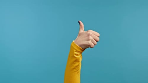 Hand Gives a Thumbs Up on Blue Background