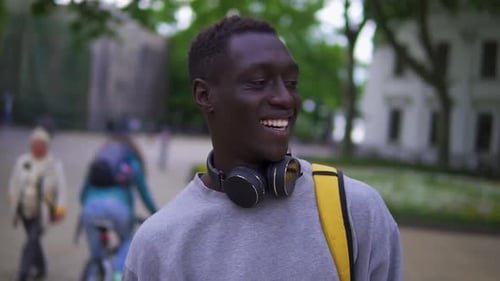 Close Up Portrait of Handsome Young African American Man Smiling Cheerful at Camera Enjoying Calm