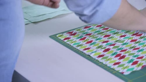 Hände arrangieren einen bunten Stoff