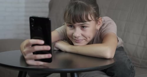 Girl Relaxing with Smartphone Indoors During Daytime