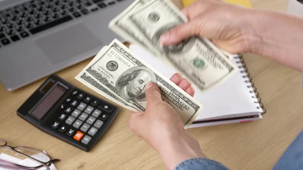 человек считает деньги на калькуляторе, рядом монитор с биржей