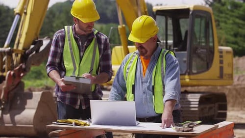 Construction workers using laptop computer