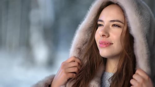 Happy Brunette Woman Wearing Hood Fur Coat at Winter Forest