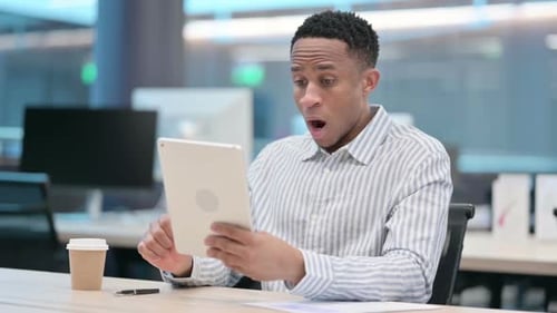 Young Adult Surprised While Using Tablet in Office