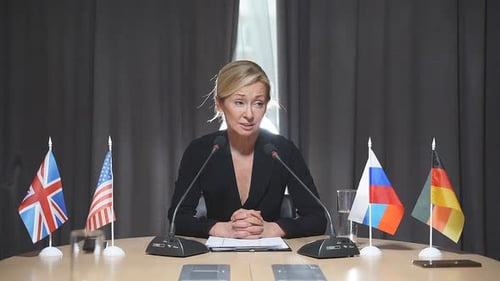 Woman at International Conference Table with Flags