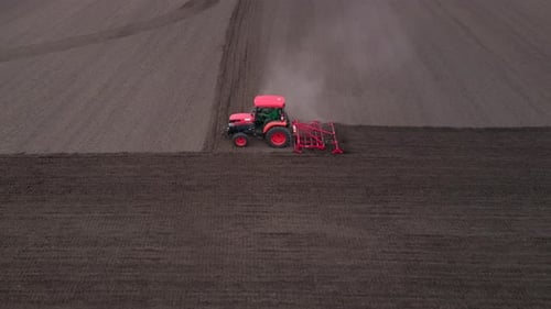 Agricultural Red Small Tractor in the Field Plowing Works in the Field