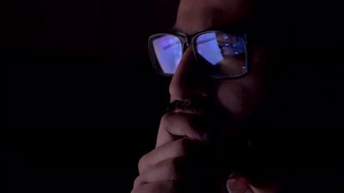 REFLECTION: Close Up of face of adult man in an eyeglasses looking a website.