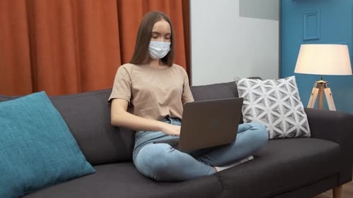 Woman with Mask Coughing While Working on Laptop