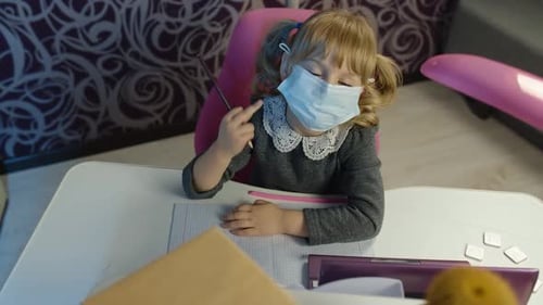 Child Girl Kid in Medical Mask Doing School Homework on Laptop Computer at Home Distance Education