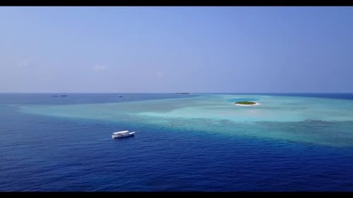 Drohnen-Panorama der ruhigen Strandreise des Resorts durch blaues Wasser mit weißem Sandhintergrund