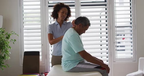 Physical Therapist Treating Patient Neck Pain in Office