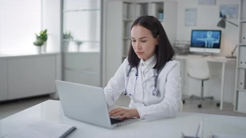 Female Doctor Working on Laptop in Office