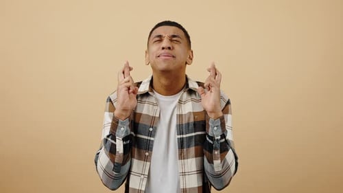 Young Emotional African American Guy Making Cherished Wish Crossing Fingers and Praying Begging to