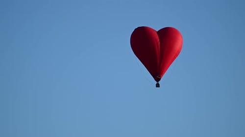 Red Heart Balloon Floating in Bright Blue Sky