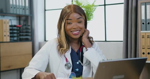 Smiling Woman Doctor with Stethoscope at Office Desk