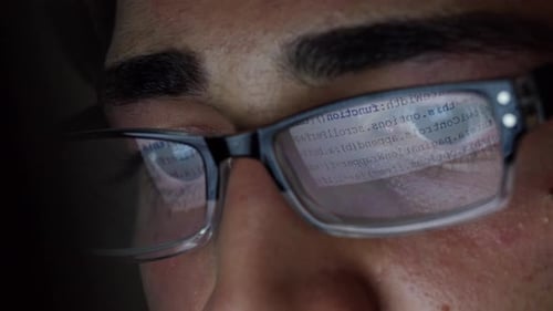 Man Wearing Glasses Looking at Code Reflection