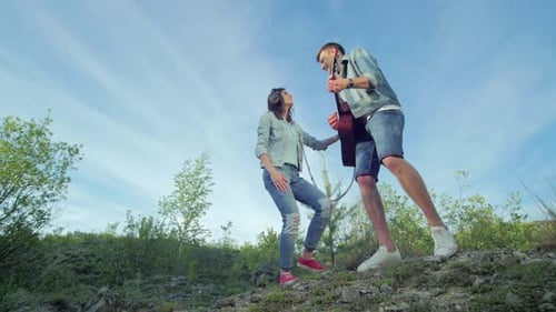 Glückliches Paar spielt Gitarre und singt