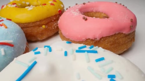 Delicious Multicolored Glazed Donuts in a Smooth Motion
