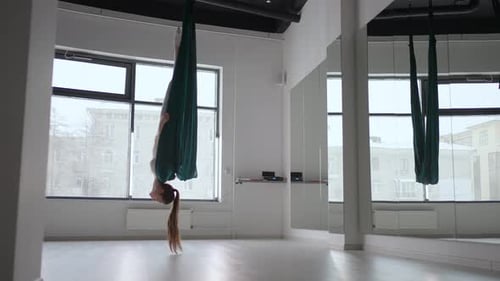 A Young Beautiful Woman Performs Exercises on a Hammock From Aero Yoga