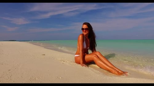 Woman happy and smiling on exotic island beach vacation by blue sea with white sandy background of t
