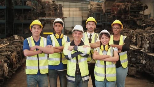 Various ethnics of engineers in uniforms and helmets in warehouse factory.