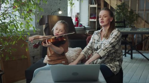 Child Practices Violin at Home with Mother
