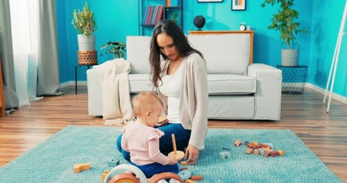 Mother and Baby Playing with Wooden Blocks at Home