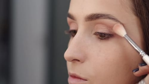 Vue recadrée du visage d'une fille en train de se maquiller