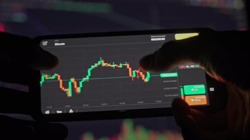 Hand Analyzing Cryptocurrency Stock Chart on Smart Phone